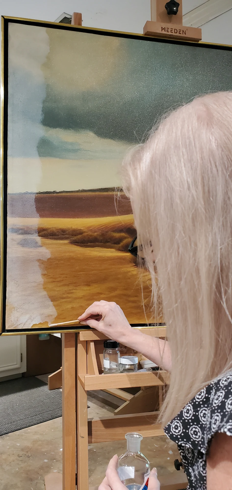 Conservator performing careful surface treatment on a painting
