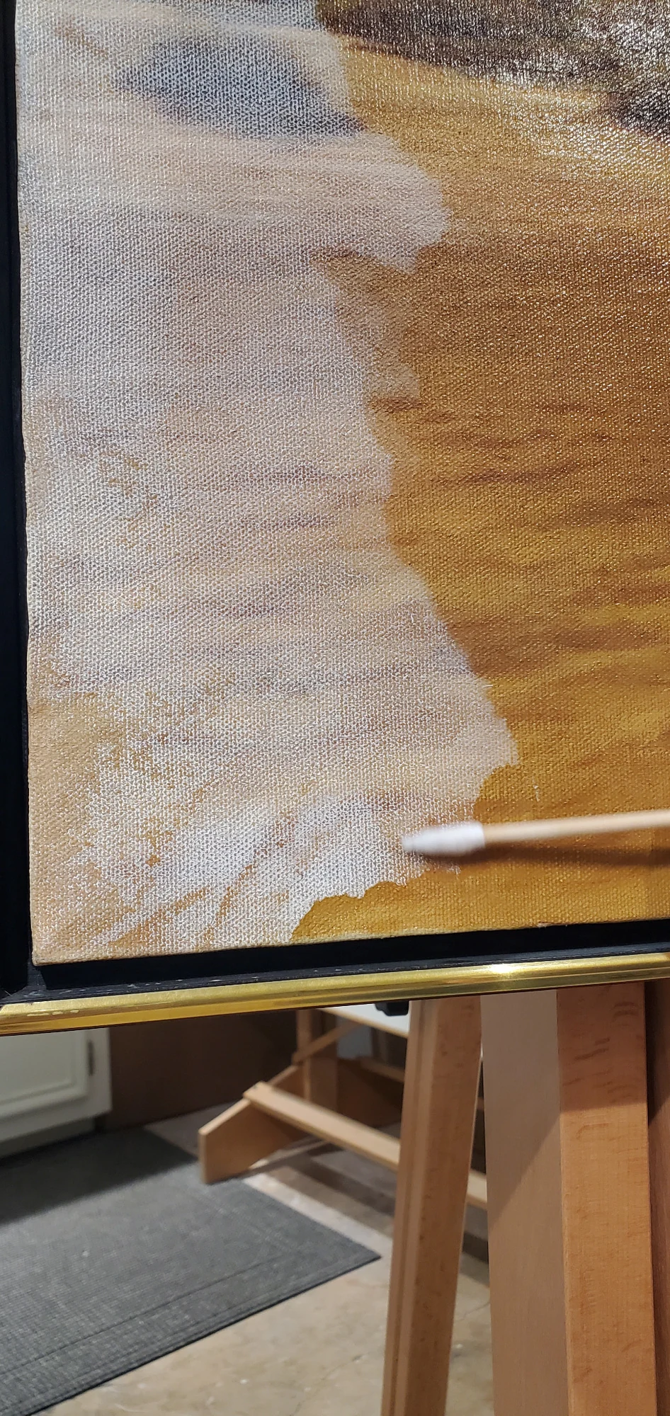 Cotton swab cleaning a painting surface